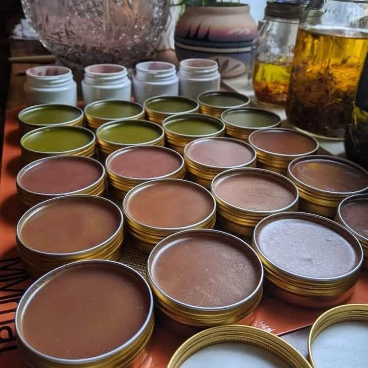Hand-poured herbal salve tins lined up after preparation