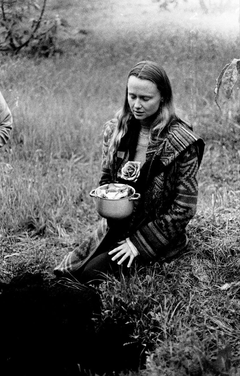 A quiet, grounded moment — woman seated in a field