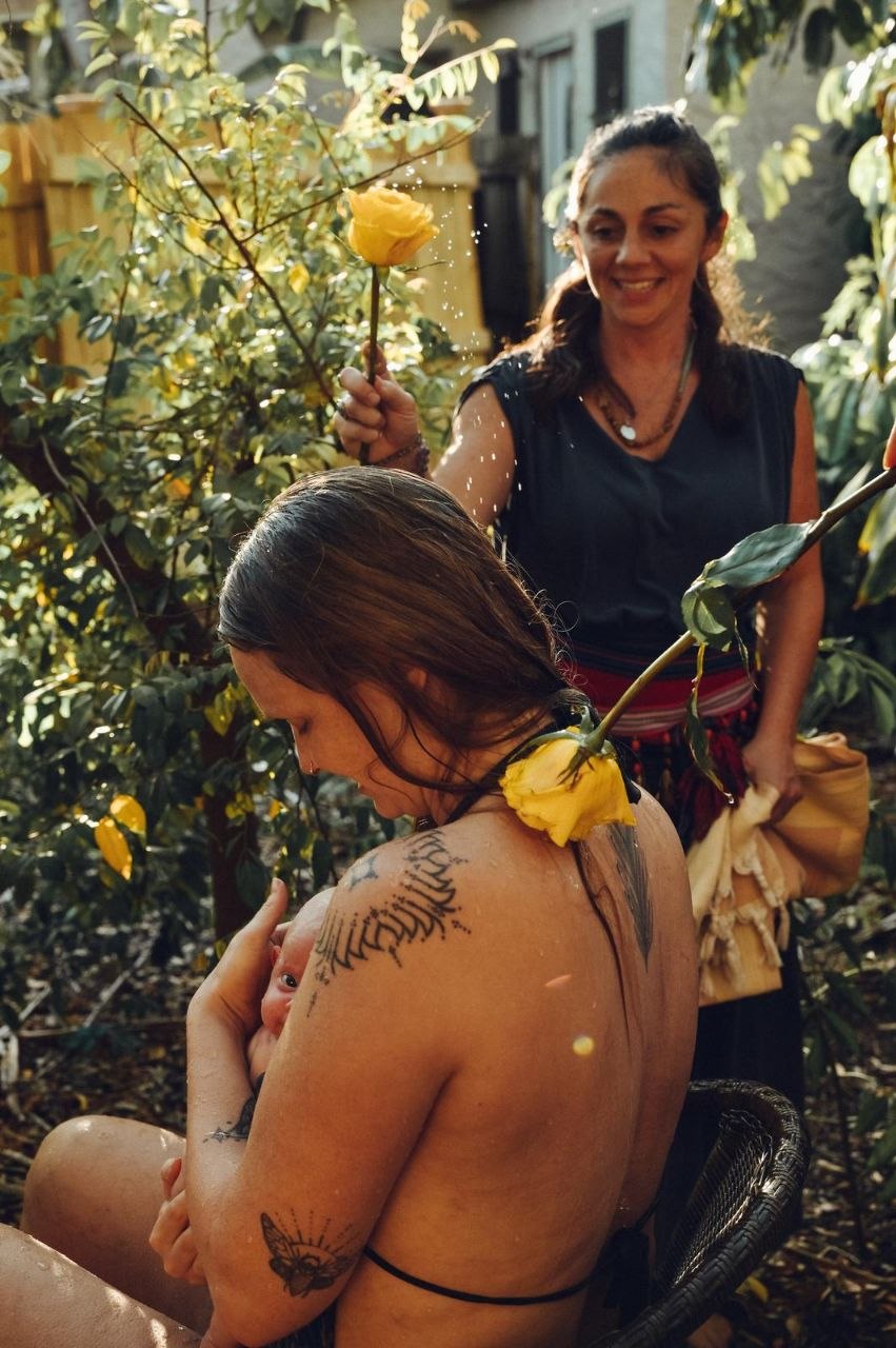 Outdoor mother blessing — a new mother held with yellow roses
